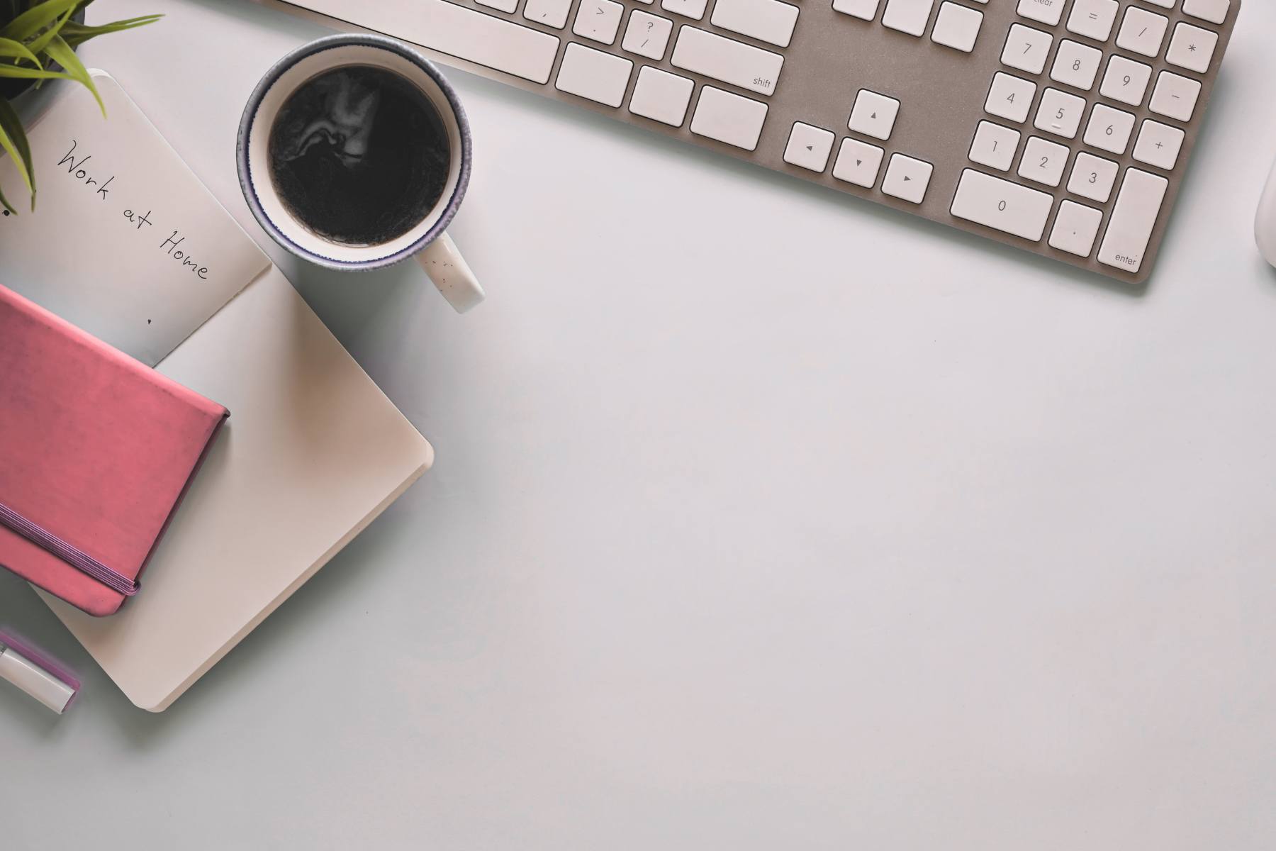 Minimalist desk with coffee, keyboard, and notebook