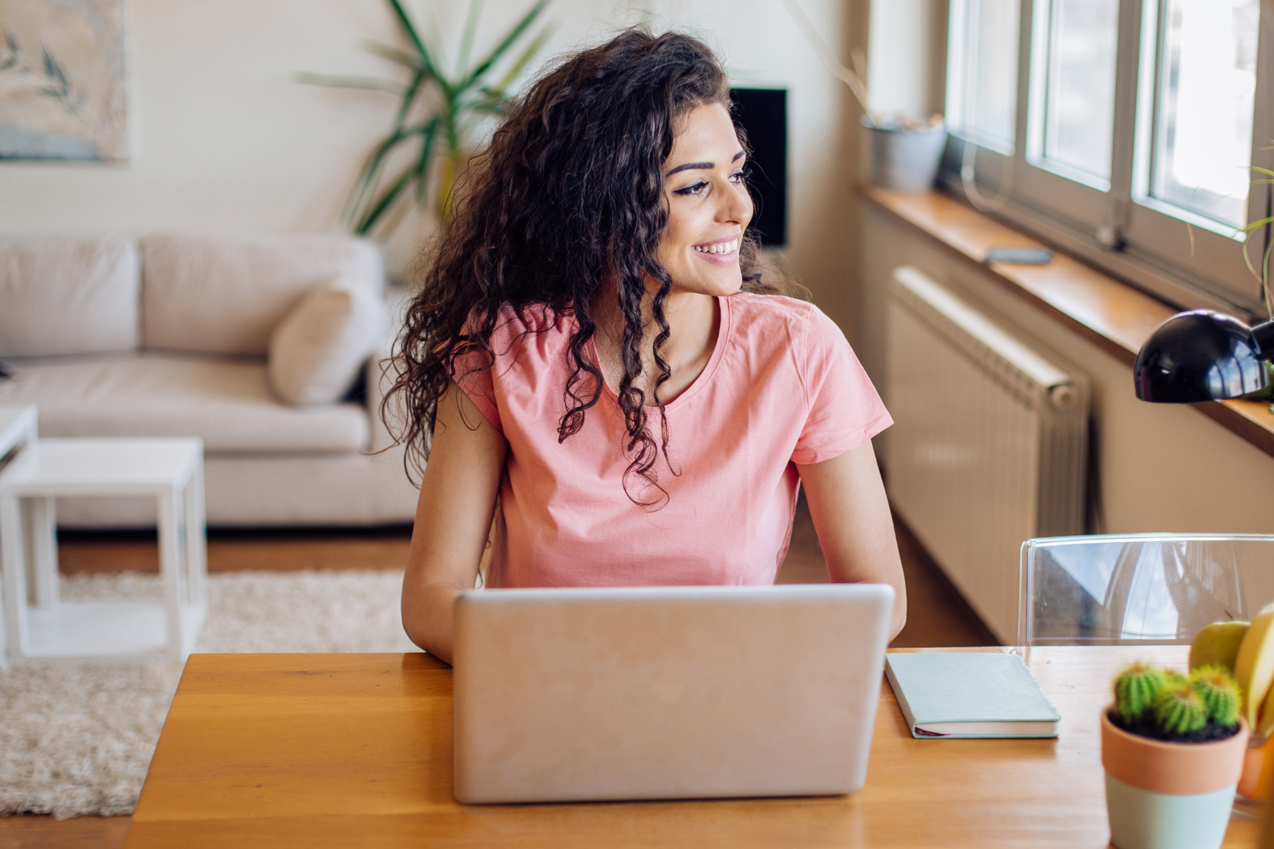 Woman smiling while working on a laptop from home