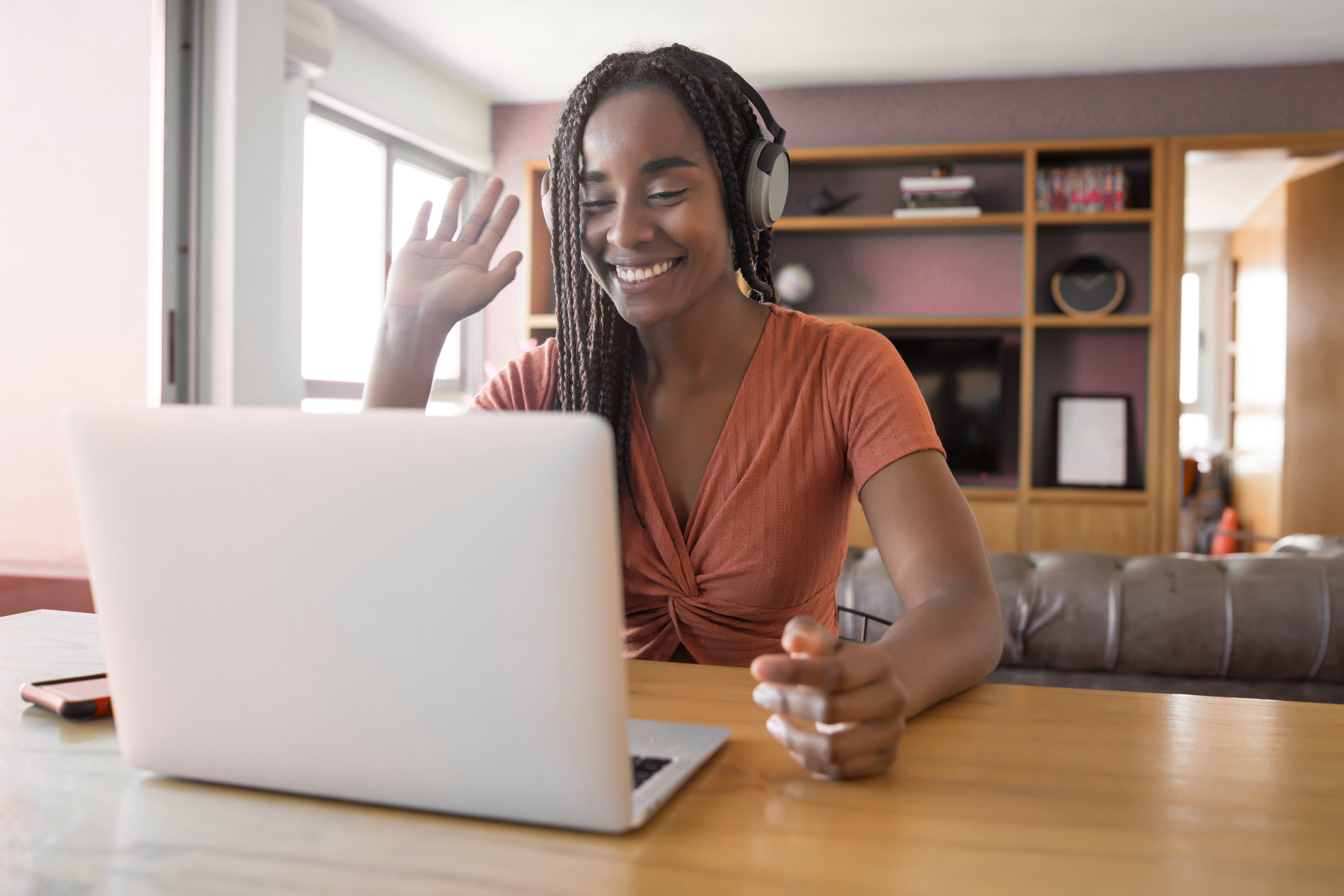 Woman on a video call waving and smiling